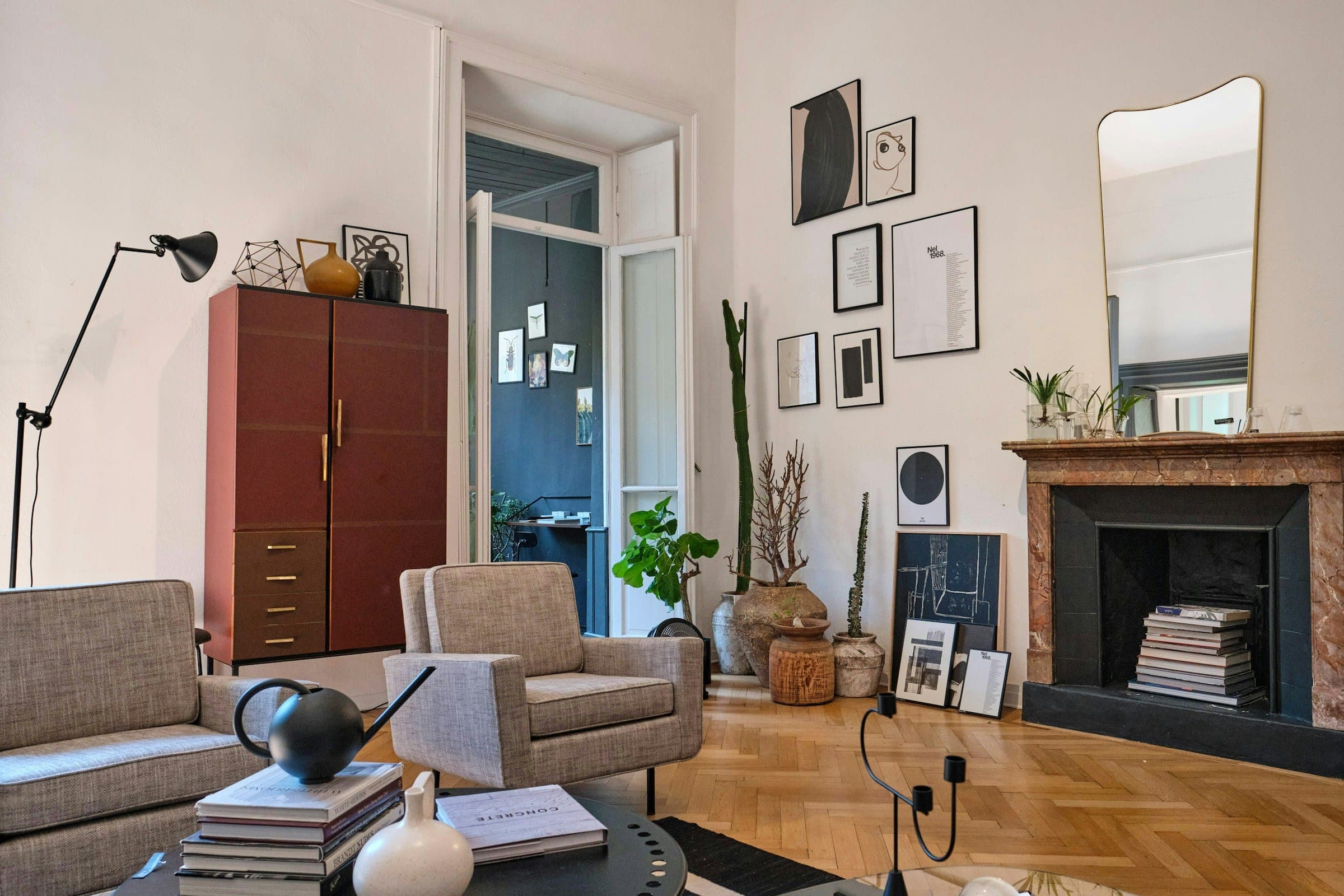 The same sitting room from the left, with a floor lamp, sofa and armchair